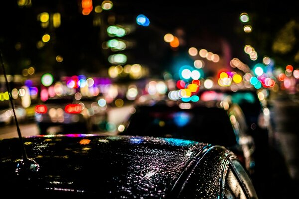 Luces de la ciudad nocturna en el tráfico después de la lluvia