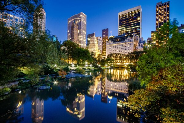 The evening menapolis is reflected in the water surface of a calm lake