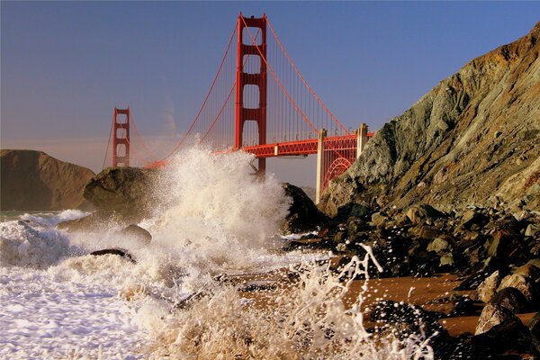 Bridge waves crashing against rocks