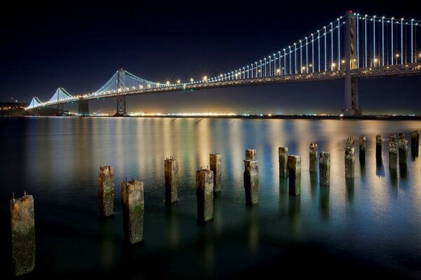 San Francisco, w nocy światła w pobliżu mostu pięknie płoną