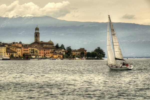 Eine Yacht vor dem Hintergrund der Berge, die am Gardasee schwimmt