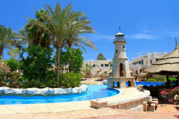 Piscina al aire libre con faro decorativo en el hotel