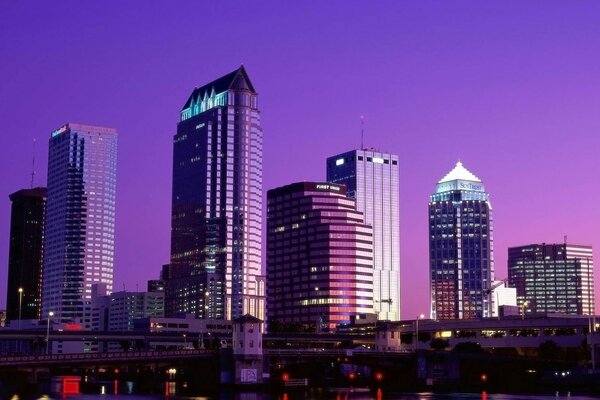 Skyscrapers at night against a purple sky