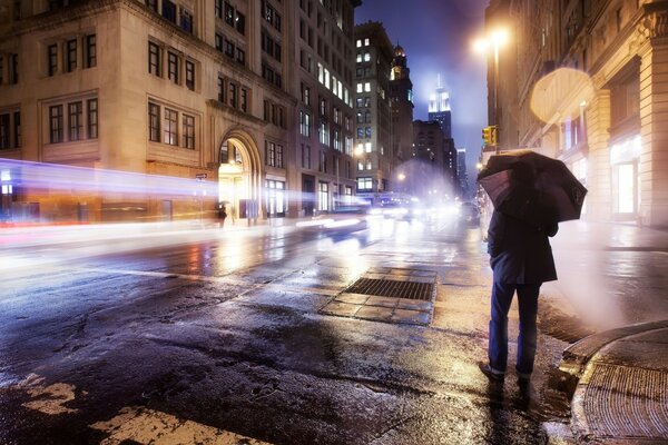 A man with an umbrella is standing on the street