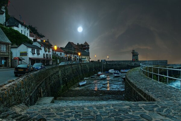 A bright moon over a dark paved street