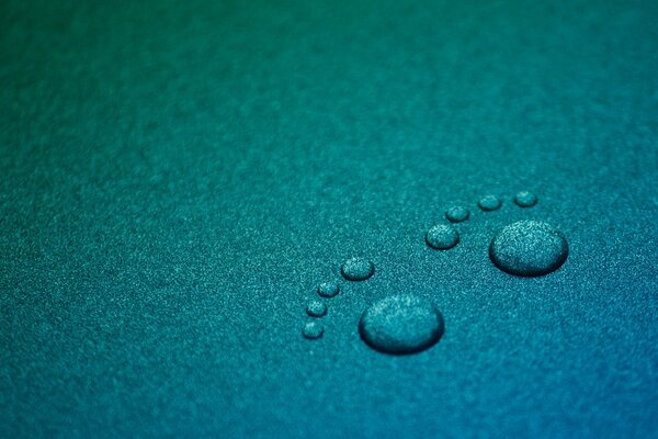 Minimalismo su sfondo turchese, con gocce d acqua e tracce di gambe su una superficie blu