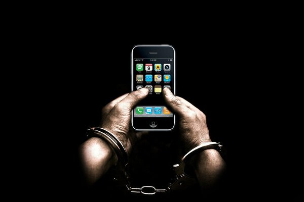 A man in handcuffs with a phone in his hands