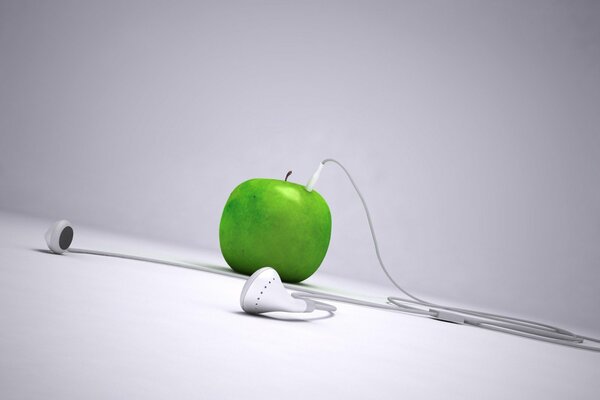 Зелёное яблоко с белыми наушниками