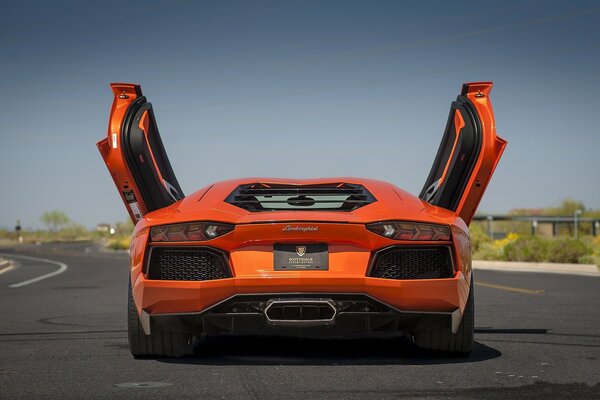 Vista posteriore Lamborghini arancione con porte aperte
