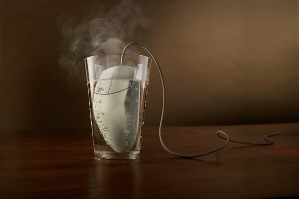 A computer mouse in a glass of water