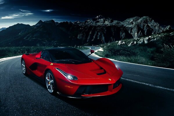 Czerwone Ferrari je nocną górską drogą