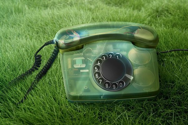 Transparentes Telefon auf grünem Gras