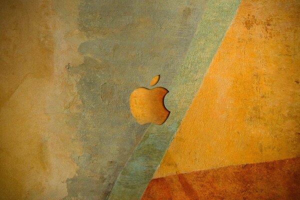 Emblemat apple w pomarańczowych odcieniach na tle ściany