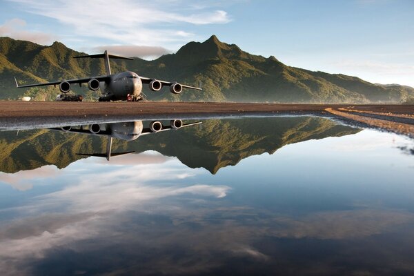 Ein riesiges Flugzeug im Flug und in der Reflexion des Wassers