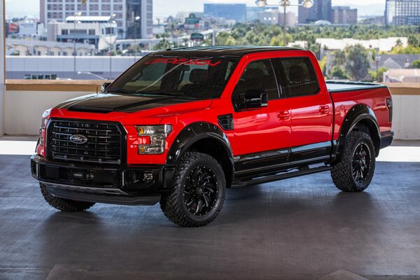 A tuned Ford pickup truck with a black and red body