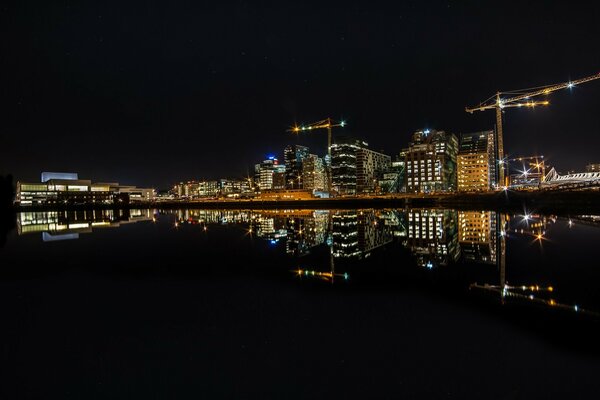 Nachtstadt und Fluss, die Lichter reflektieren