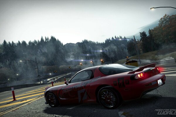 Mazda rojo en la carretera. Alrededor del bosque