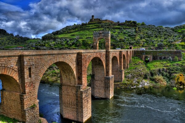 Puente de ladrillo sobre el río en colores brillantes