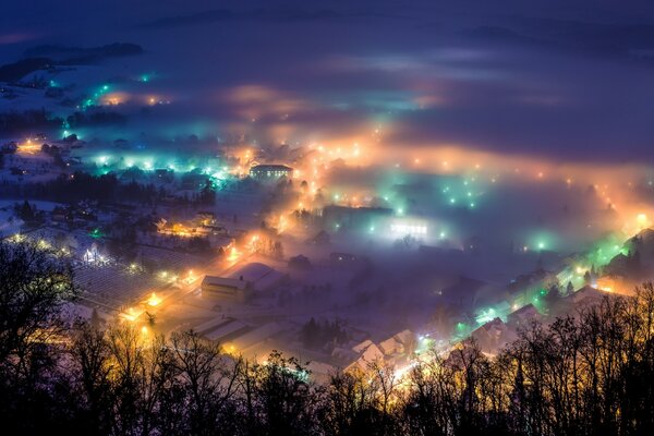 Nebelige Nachtstadt aus der Höhe