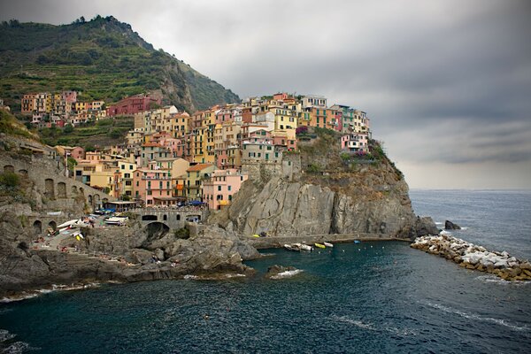 Eine helle Stadt in Italien, die auf einer Klippe steht