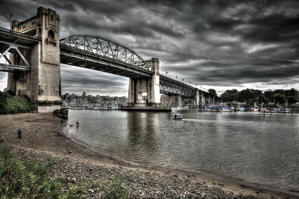 A bridge over a river against a cloudy sky