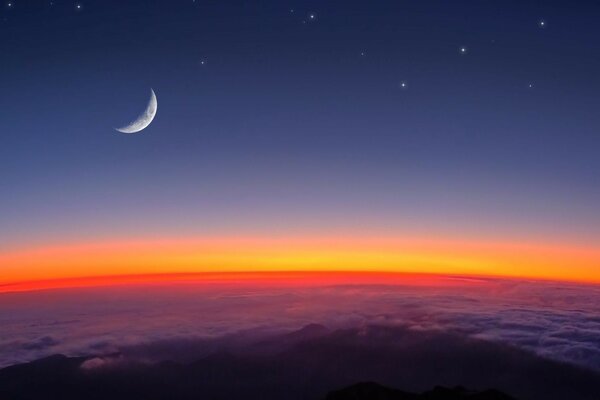 Image of the moon and stars above the clouds