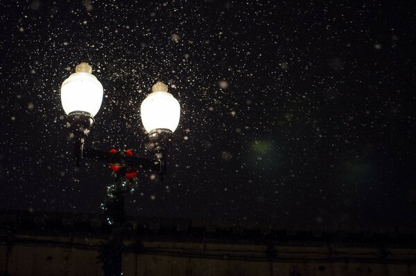 Ночной фонарь испускающий свет под снегом