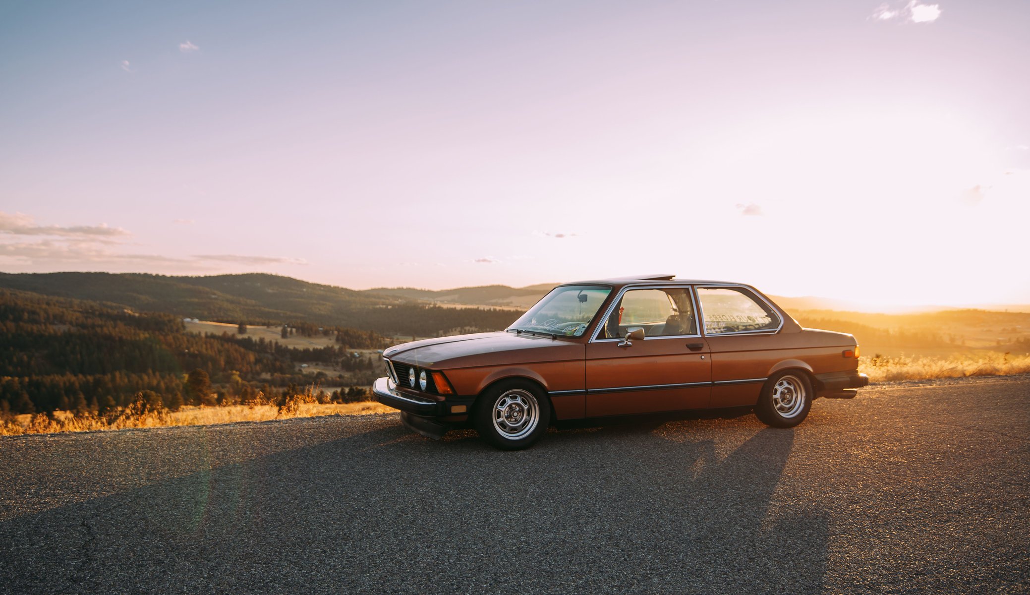 bmw e21 ombre route roues phares vallée collines horizon nuages ciel soleil