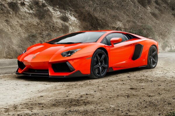 Red sports Lamborghini on a sandy road