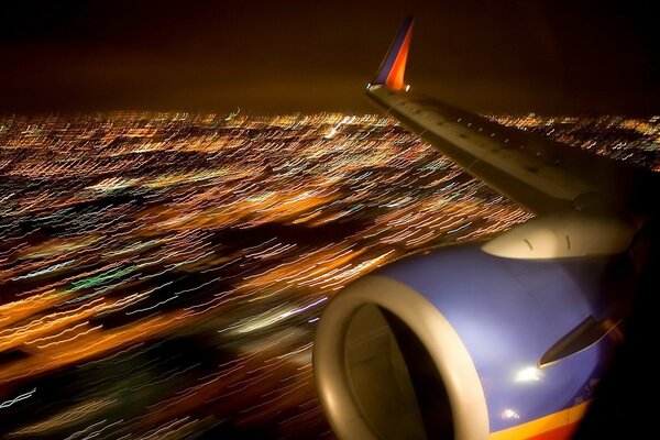 View from the porthole of the airplane wing and city lights