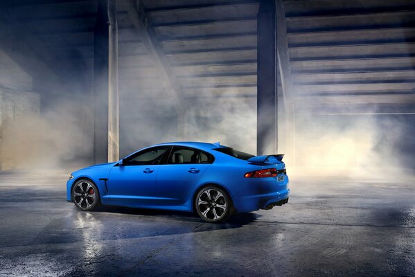 Light blue jaguar xfr-s in clouds of smoke