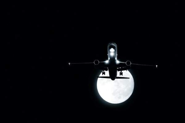 Vol de nuit de l avion sur fond de lune