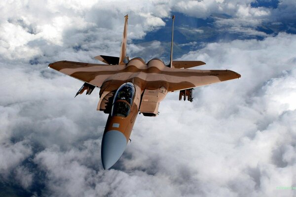 A fighter plane flies through large clouds