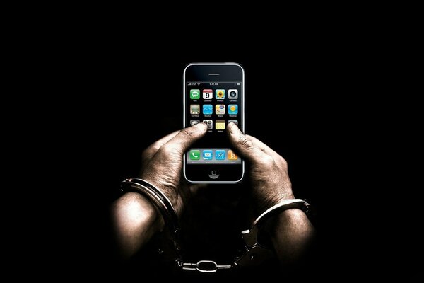 Men s hands in handcuffs hold the phone