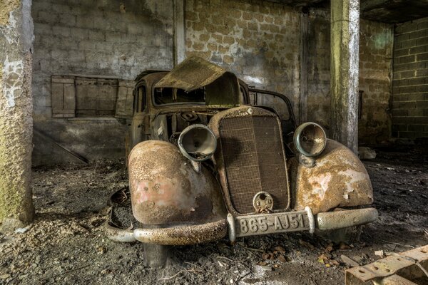 Viejo coche oxidado en el garaje