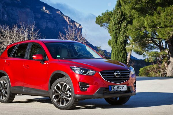 Crossover Mazda CX-5 rosso su uno sfondo roccioso