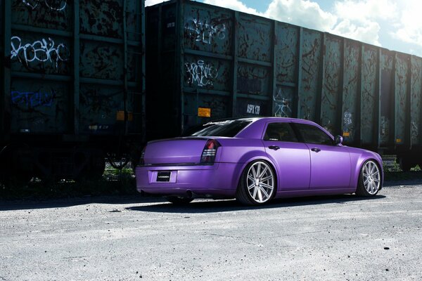 Purple Chrysler on the background of a freight car