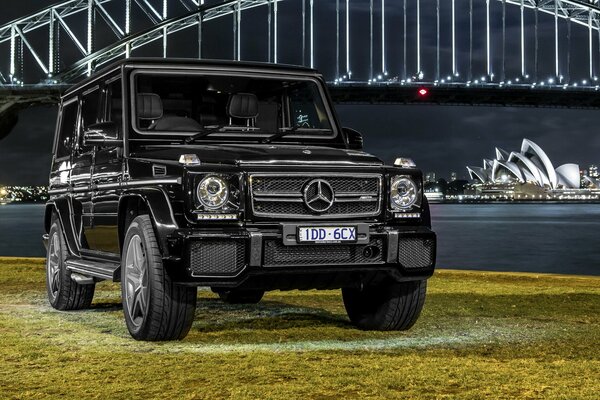 Black car on the background of the ocean and the city