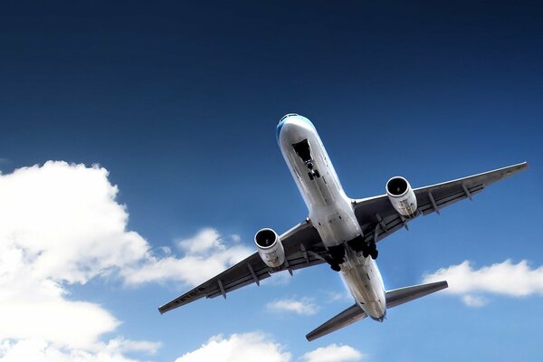 El avión vuela en el cielo contra las nubes