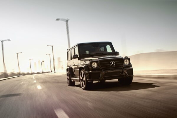 A beautiful, black car is driving along the road