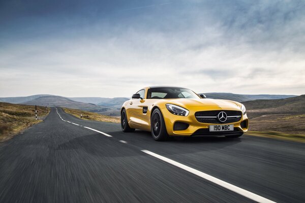 Żółty Mercedes, który jeździ po drodze