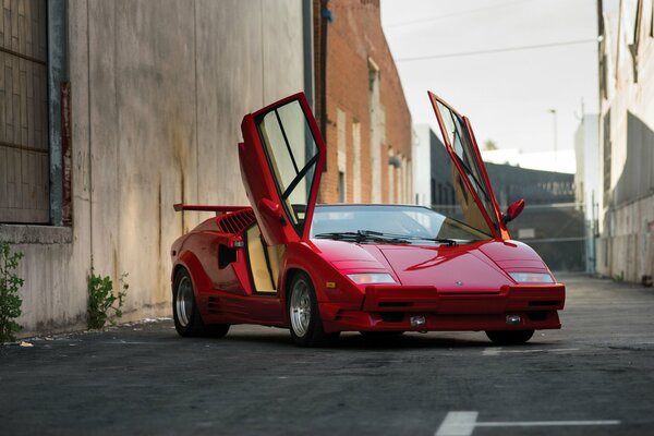 Red Lamborghini countach with raised doors, front view, street location