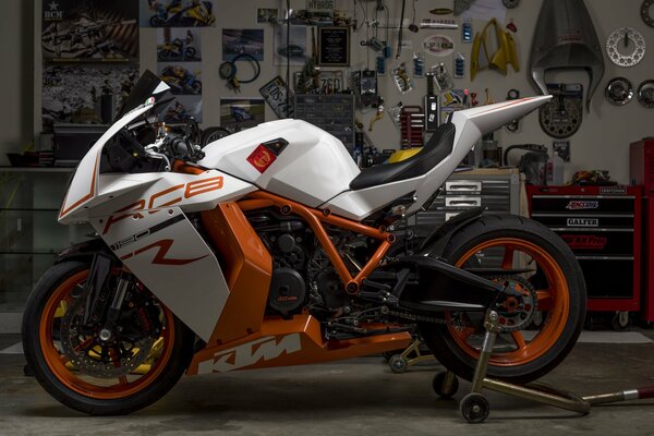 The orange sport bike is in the garage