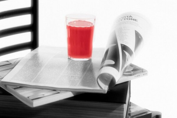 Magazine on a chair with juice in a glass