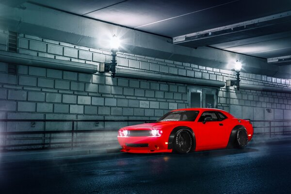 Red car on the background of a brick wall on the road