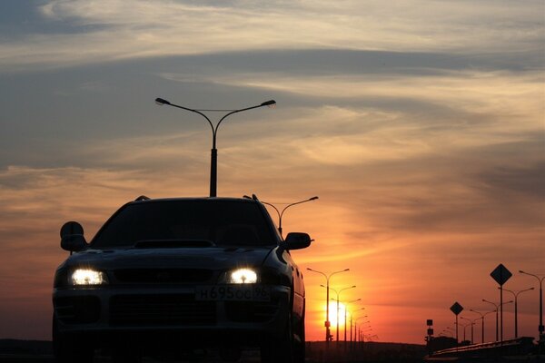 Headlights of a passenger car at sunset