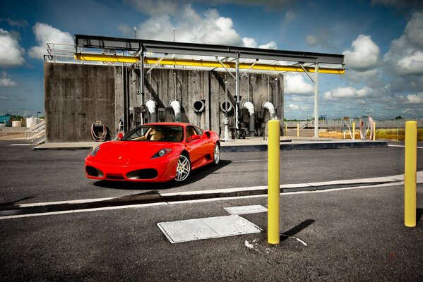 Red Ferrari f430 at the building with pipes