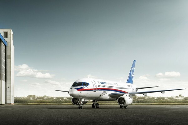 The Russian Sukhoi Superjet 100 aircraft stands at the hangar