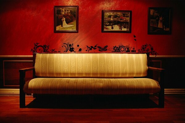 Vintage Sofa vor dem Hintergrund der roten Wände mit ungewöhnlichen Mustern