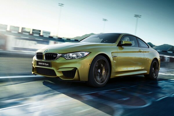 A gold-colored car is driving on the road